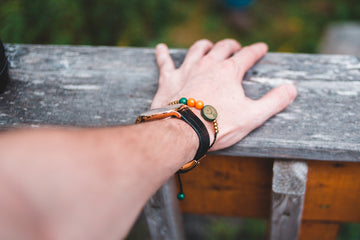 a person's hand resting on a wooden bench
