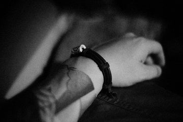 a black and white photo of a person wearing a bracelet