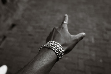 A hand with a bracelet points upwards
